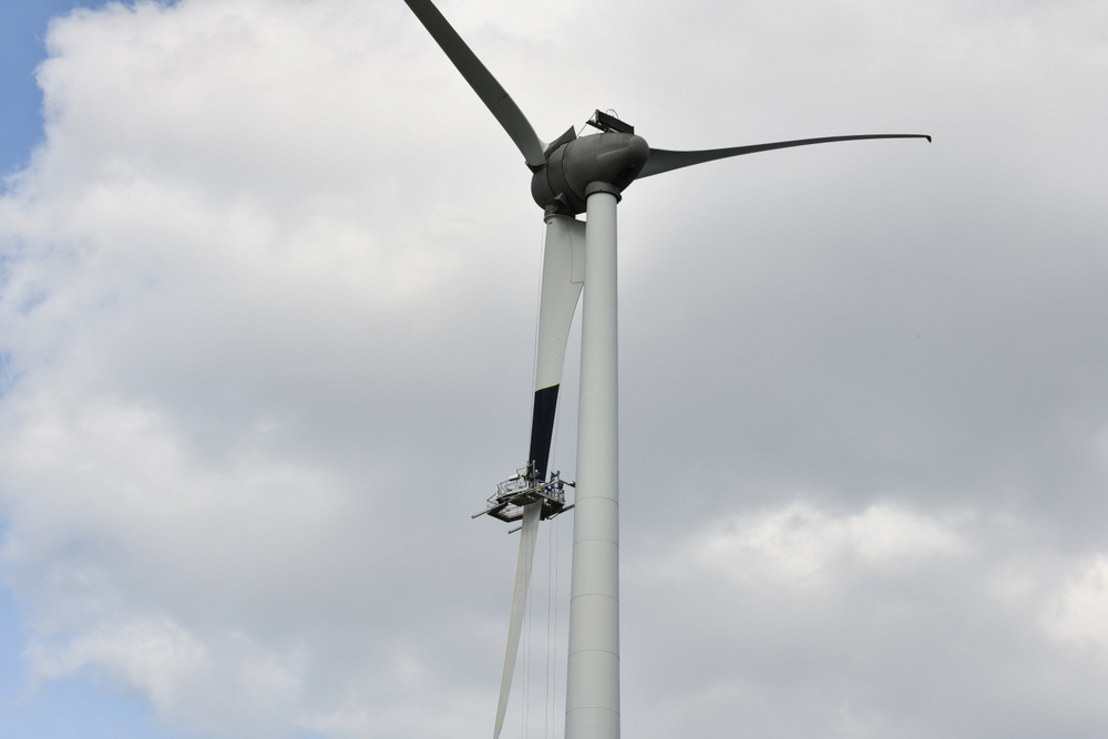 Een wiek van een windturbine wordt zwartgeverfd 